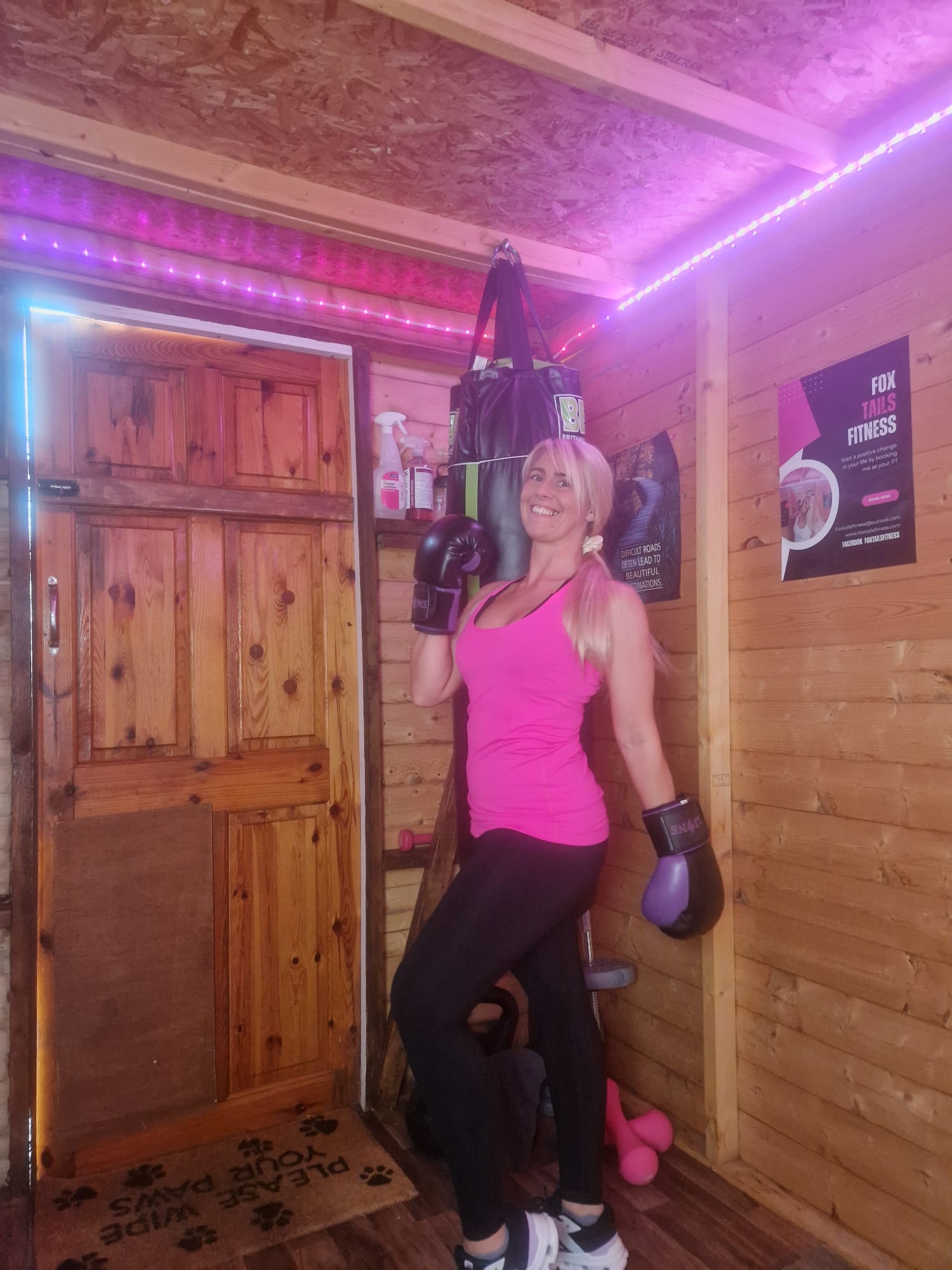 Danielle wearing boxing gloves beside a punch bag