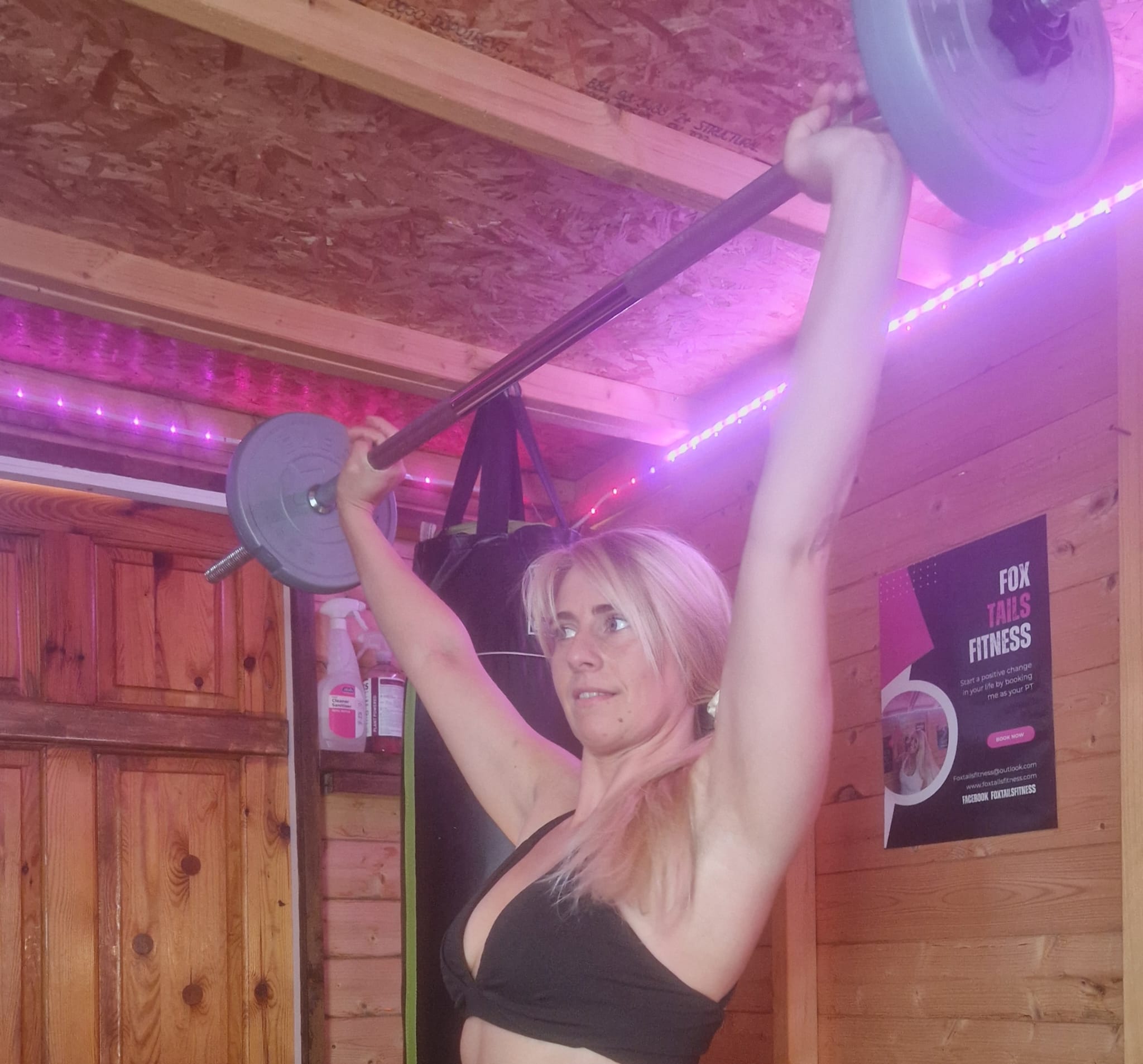 Danielle pressing a barbell overhead in the Foxtail Fitness studio
